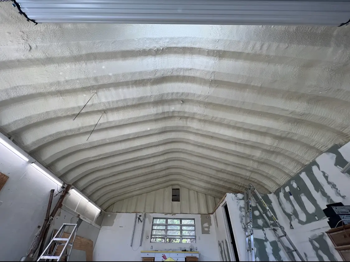 Spray polyurethane foam applied to the underside of a metal roof deck in Greenwood